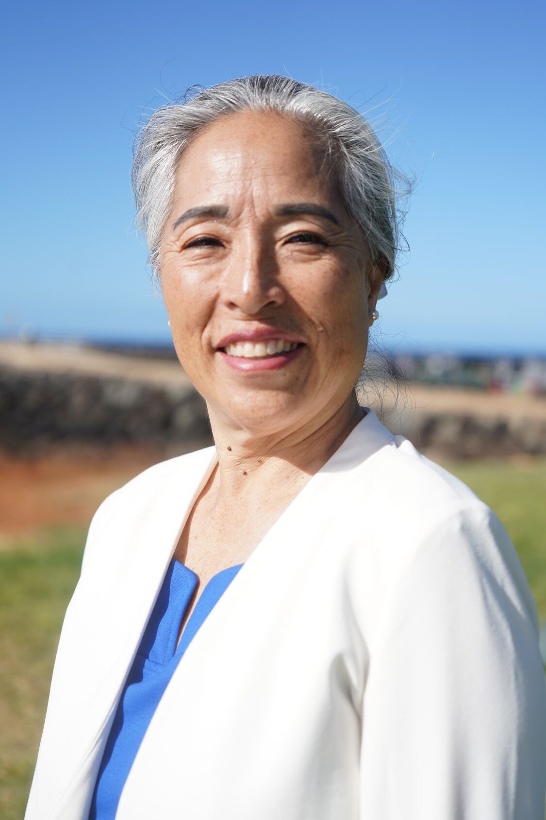 Darci Shin, founder of Sprouts Life Coaching, smiling by the ocean in Honolulu